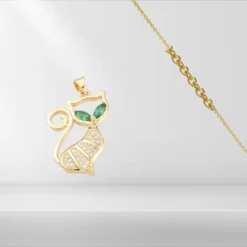 Pendentif Chat 10 Pendentif chat plaqué or contour ajouré, yeux en zirconiums verts émeraude navette et corps pavé de zirconiums blancs, vendu avec chaîne dorée fine – collier fantaisie femme