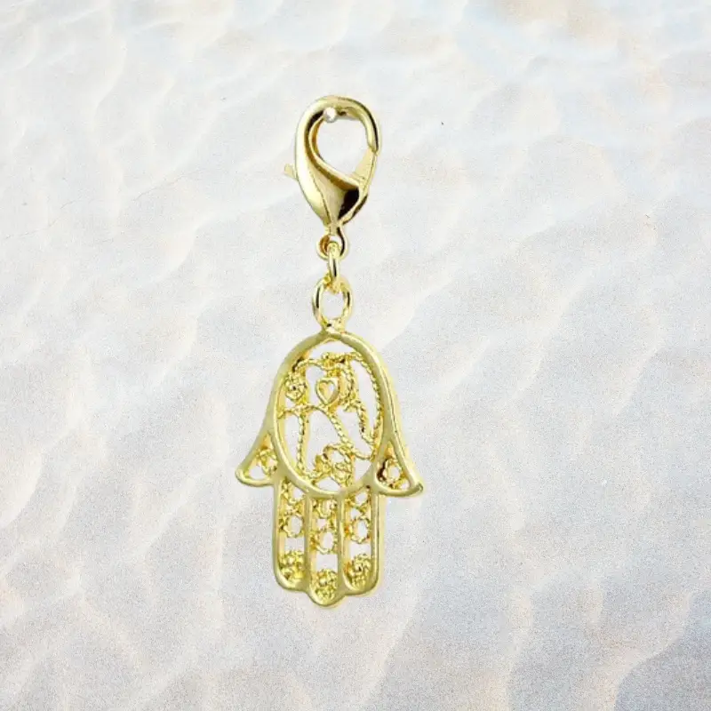 Charm Main de Fatma 1 Charm Main de Fatma ciselée en métal doré plaqué or 1 micron, avec mousqueton, motifs ajourés et cœur central, fond blanc, 25x23 mm