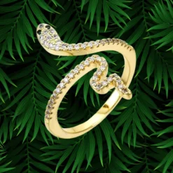 Bague Serpent Femme 12 Bague serpent femme dorée réglable entièrement pavée de zircons blancs, yeux noirs, corps sinueux biface texturé et lisse, bijou serpent plaqué or élégant sur fond tropical