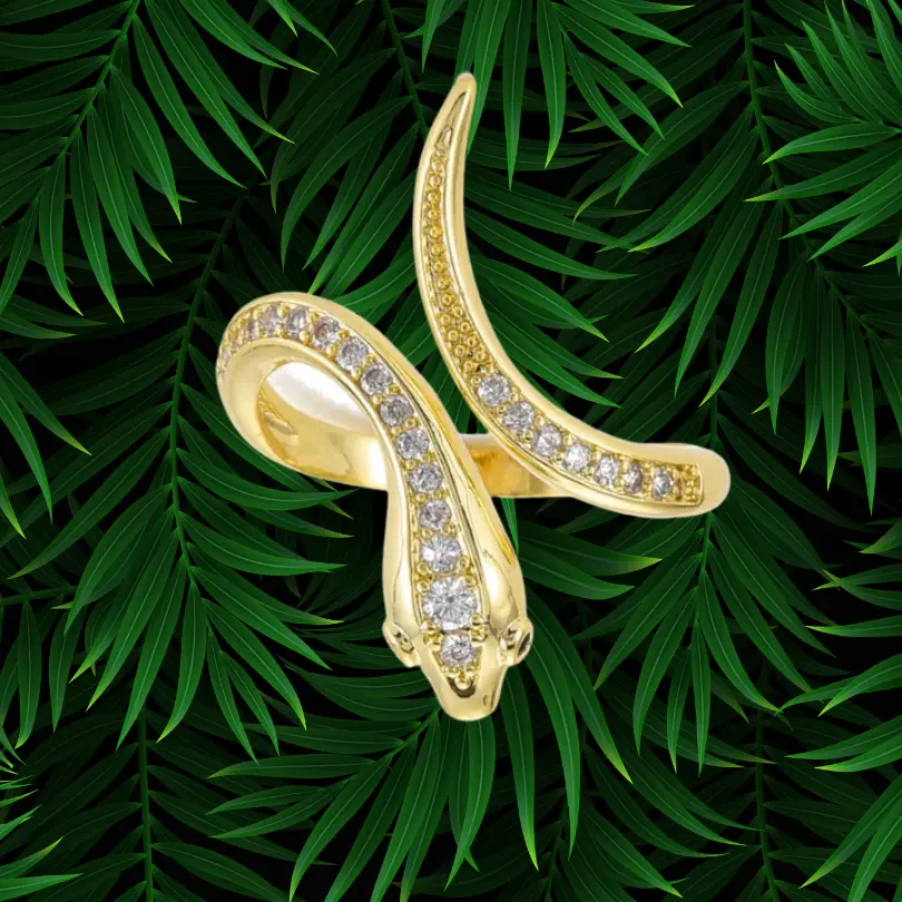 Bague Serpent Femme 7 Bague serpent femme dorée plaquée or, corps allongé en X serti d'une ligne de zirconiums blancs, tête centrale détaillée, anneau ouvert ajustable, bijou serpent statement sur fond de palmier