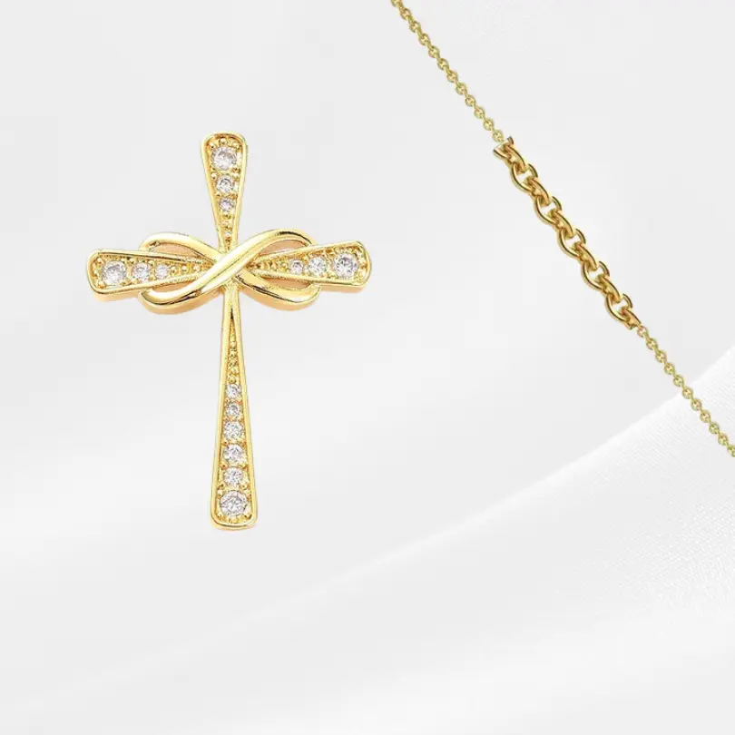 Croix Pendentif 3 Collier croix pendentif doré symbole infini orné de zircons pour femme — pendentif croix religieuse avec nœud infini pavé strass sur chaîne fine dorée, fond blanc épuré