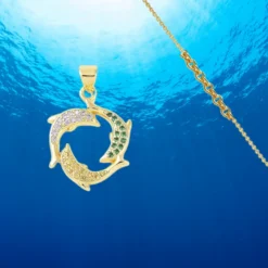 Pendentif Dauphin 7 Collier chaîne pendentif dauphins dorés ornés de zirconiums colorés, bijou marin raffiné sur fond bleu océan