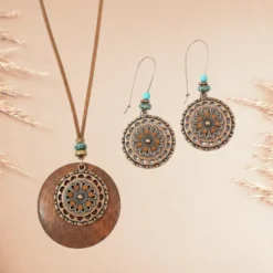 Parure Bijoux Bohème Chic 8 Parure de bijoux bohème ethnique composée d’un collier pendentif rond en bois et métal vieilli, avec boucles d’oreilles assorties décorées de motifs floraux et perles turquoise.